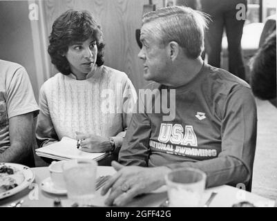 Austin Texas USA, 1984: Des femmes écrivains sportifs interviews entraîneur olympique de natation Don Gambril pendant la rencontre pré-olympique sur invitation. Banque D'Images