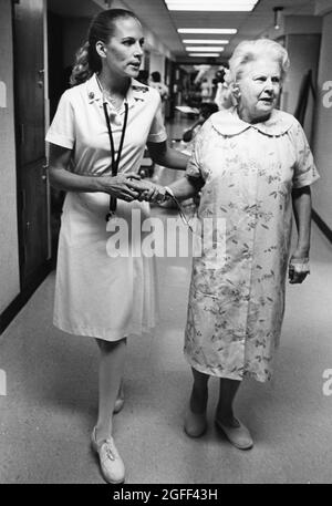 Austin Texas USA, vers 1990: L'infirmière aide une femme âgée à marcher dans le hall à la maison de soins infirmiers. ©Bob Daemmrich Banque D'Images