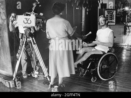 Austin Texas USA, 1994: Une journaliste de télévision féminine interview un homme en fauteuil roulant tandis que le caméraman enregistre l'interaction. ©Bob Daemmrich Banque D'Images