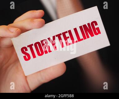 Homme d'affaires tenant une carte avec mot Storytelling. Rédaction de récits marketing concept Banque D'Images