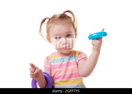 jeune fille caucasienne jouant avec des cercles des jouets éducatifs des enfants et regardant sur l'appareil photo Banque D'Images