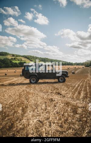 Canterbury, Kent, Royaume-Uni. 25 août 2021. Une moissonneuse-batteuse récolte du blé sous un ciel ensoleillé, près de Canterbury, dans la campagne du Kent. Crédit : Kevin Bennett/Alay Live News Banque D'Images