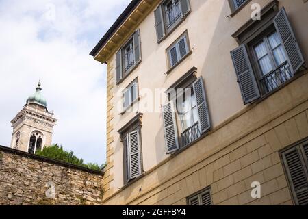 Citta Alta, Bergame, Italie: Scène typique de rue; palazzos avec des fenêtres à volets; aperçu de la tour de S. Maria Maggiore. Banque D'Images