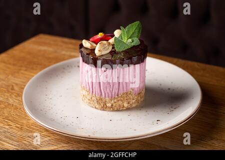 Gâteau au fromage de framboise mini avec décoration sur plaque sur table en bois Banque D'Images