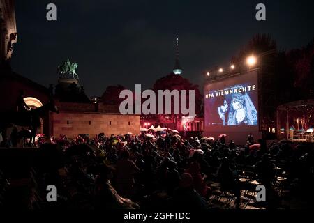 Berlin, Allemagne. 25 août 2021. Sous la pluie, les visiteurs des Ufa film Nights sur l'île Museum attendent le début du film. Après une pause pandémique, les Ufa film Nights retournent à l'île des musées à Berlin. Du 25 au 27 août, plusieurs films classiques silencieux sont présentés. Credit: Paul Zinken/dpa/Alay Live News Banque D'Images