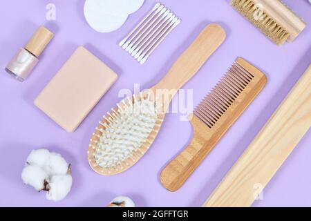 Articles écologiques de beauté et d'hygiène en bois, comme le peigne et le savon sur fond violet Banque D'Images