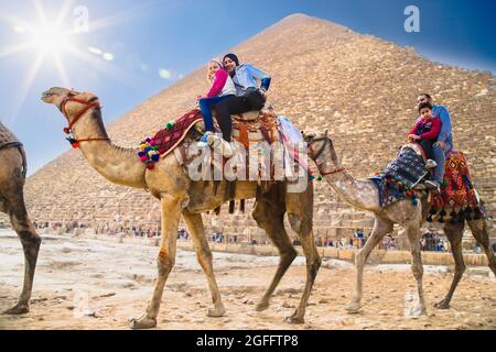 Caikro, Égypte-31 janvier 2020 : touristes en chameaux près des grandes pyramides de Gizeh, Égypte Banque D'Images