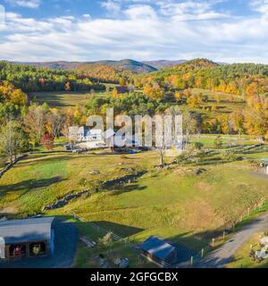Vue aérienne de la ferme équestre du Vermont dans le feuillage d'automne avec granges et maison Banque D'Images