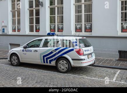 Brugge, Flandre, Belgique - 4 août 2021 : chariot de poste de police Opel blanc et bleu stationné dans la rue. Banque D'Images