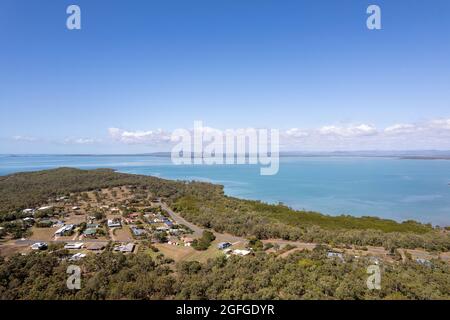 Un drone survoler un petit canton de bord de mer niché au milieu du Bush au bord d'une mer bleue Banque D'Images