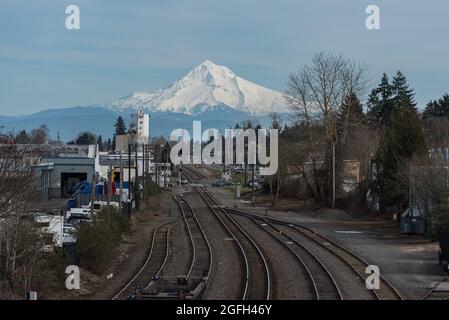 Nature et ville avec vues sur le sommet enneigé de la montagne Mt Hood sur les voies de train industrielles à Portland, Oregon, Pacifique Nord-Ouest des États-Unis Banque D'Images