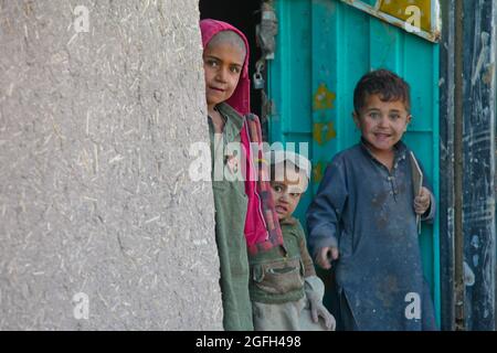 Les enfants afghans locaux regardent de leur porte d'entrée, tandis que les Afghans locaux et les membres du service américain participent à une Shura dans le village de Spinah, district d'Omna, province de Paktika, Afghanistan, 23 octobre, 2011. (ÉTATS-UNIS Photo de l'armée par la SPC. Jacob Kohrs/libéré) Banque D'Images