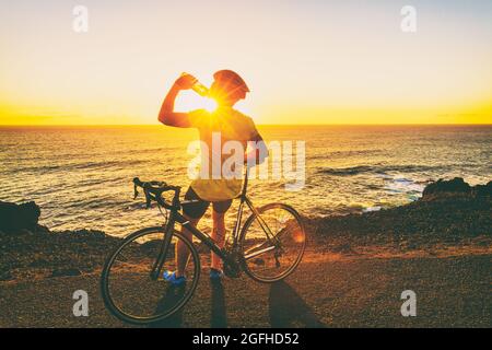 Athlète cycliste homme buvant de l'eau à vélo Banque D'Images