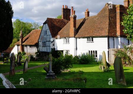 Des maisons à colombages qui redorent sur le cimetière de l'église Saint-Michel peu de temps avant le coucher du soleil à Smarden, Kent, Angleterre Banque D'Images