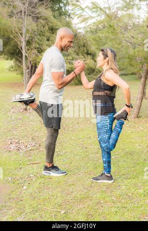 Faites de l'exercice à un couple en tenant une main dans le parc Banque D'Images