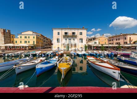 Port du petit village de Bardolino avec bateaux de pêche amarrés, station touristique sur la côte du lac de Garde (Lago di Garda). Vérone, Italie. Banque D'Images