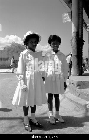 Zwei einheimische Mädchen in weißen Kleidern lassen sich fotografieren, Haïti Port-au-Prince, 1967. Deux jeunes filles de la région vêtues de blanc ont pris leur photo, Haïti Port-au-Prince, 1967. Banque D'Images