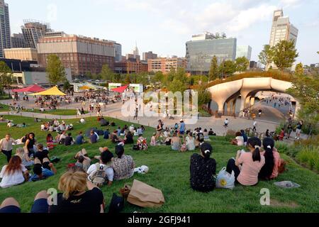 Les gens se prélassant sur l'herbe les jours choisis le public est autorisé sur la pelouse de Little Island @ Pier 55 au Hudson River Park, New York, NY. Banque D'Images