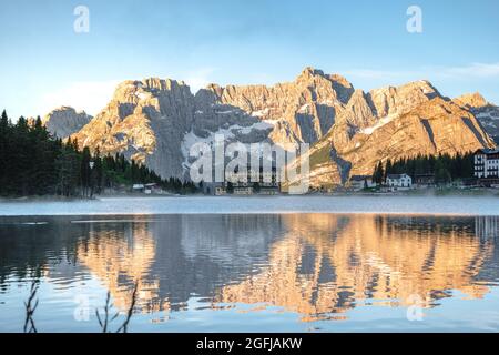 La tranquillità di un lago alpino subito dopo l'alba, le montagne dorate e la foschia sull'acqua. Lago di Misurina, Belluno, Vénétie. Italie. Banque D'Images