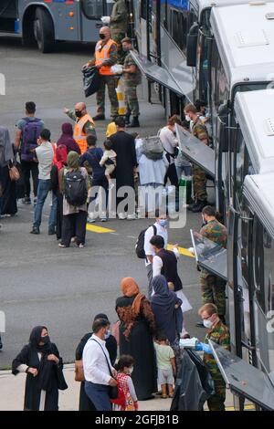 L'illustration montre des personnes qui passent dans des bus à l'arrivée d'un avion affrété d'Air Belgium Airbus A340 transportant des personnes évacuées de l'Afghanistan Banque D'Images