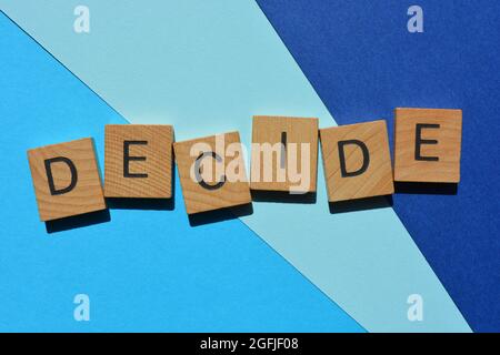 Décidez, mot en lettres de l'alphabet en bois isolées sur fond bleu comme titre de bannière Banque D'Images