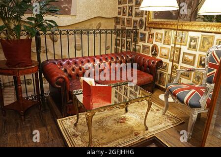 Décoration intérieure et salon décoré d'un canapé en cuir rouge et d'un mobilier ancien Banque D'Images