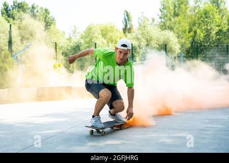 patineurs avec des bombes de fumée colorées. Skateboarders professionnels qui s'amusent au skate Park Banque D'Images