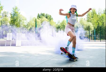 patineurs avec des bombes de fumée colorées. Skateboarders professionnels qui s'amusent au skate Park Banque D'Images