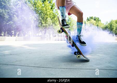 patineurs avec des bombes de fumée colorées. Skateboarders professionnels qui s'amusent au skate Park Banque D'Images