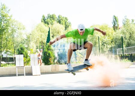 patineurs avec des bombes de fumée colorées. Skateboarders professionnels qui s'amusent au skate Park Banque D'Images