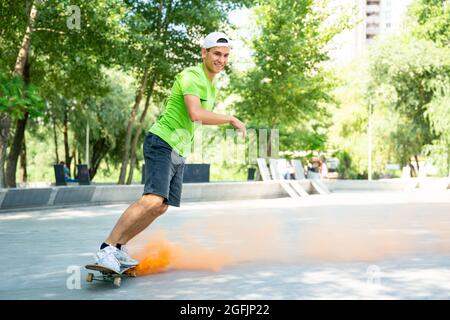 patineurs avec des bombes de fumée colorées. Skateboarders professionnels qui s'amusent au skate Park Banque D'Images