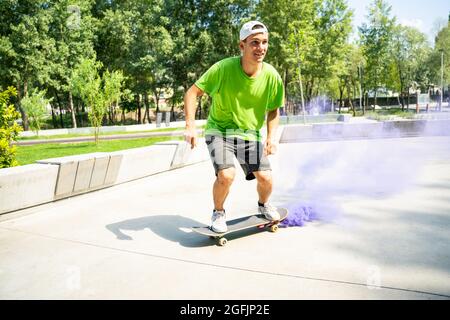 patineurs avec des bombes de fumée colorées. Skateboarders professionnels qui s'amusent au skate Park Banque D'Images