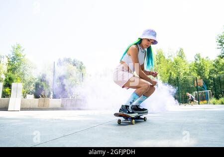 patineurs avec des bombes de fumée colorées. Skateboarders professionnels qui s'amusent au skate Park Banque D'Images