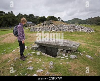 Dame à côté d'un Cairn à Kilmartin Glen regardant un Ciste de sépulture Banque D'Images