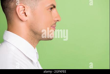 Photo de joli joli beau jeune gentleman porter chemise blanche regardant l'espace vide souriant isolé couleur de fond vert Banque D'Images