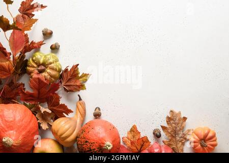 Composition festive de citrouilles, feuilles colorées sur fond blanc avec espace de copie. Maquette du jour de Thanksgiving et de l'Halloween. Vue de dessus. Banque D'Images