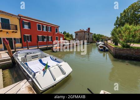 Port de l'île de Torcello avec de nombreux bateaux rapides et deux bateaux-taxis traditionnels faits de bois amarré. Lagune vénitienne, Venise, Vénétie, Italie, Europe. Banque D'Images