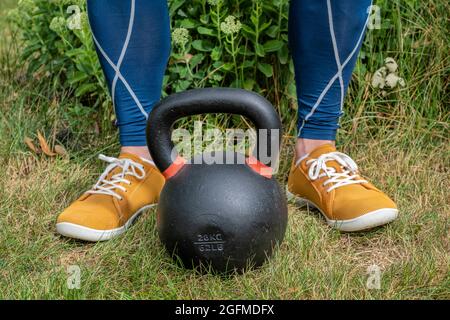 concept de fitness à la maison - entraînement de poids avec une lourde concurrence de fer kettlebell dans une cour Banque D'Images