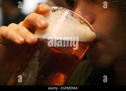 Photo du dossier datée du 01/12/06, d'un homme qui boit une pinte de bière. Les pubs serviront environ six millions de pintes de moins pour ce jour férié que la même période en 2019, a déclaré un organisme de l'industrie. La British Beer & Pub Association (BBPA) a déclaré que ses membres s'attendaient à perdre 25 millions de livres de recettes provenant des ventes de pinte, en baisse de 10 % sur les recettes pour le même jour férié en 2019 avant l'arrivée de Covid. Date de publication : jeudi 26 août 2021. Banque D'Images