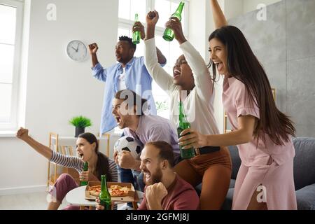 Groupe d'amis regardant le football à la télévision, criant et soutenant l'équipe préférée Banque D'Images