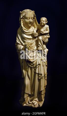 Vierge et enfant debout Marie avec enfant 1350 - 1375 Ivory Carver anonyme Boven-Rijn Allemagne Maria se tient sur la jambe gauche, a la jambe droite légèrement courbée et le pied dehors, avec son corps supérieur incliné légèrement vers la gauche. Dans sa main droite, elle tient une branche florale, sur le bras gauche, elle a l'enfant, qui est enveloppé dans son voile jusqu'à la taille. Banque D'Images