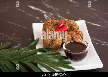 Une portion de tauhu bergedil, un plat malaisien célèbre avec sauce de soja épicée comme trempettes. Arrière-plan flou Banque D'Images