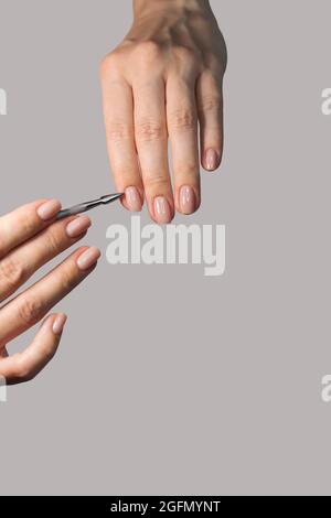 Tenez les outils de manucure dans votre main. Soins des ongles, procédure, salon de ongles. Soins à domicile, Spa, beauté. Banque D'Images