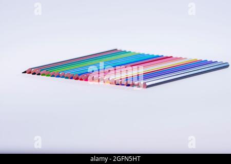 24 crayons multicolores sur fond blanc, soigneusement disposés et affûtés. Bonjour école Banque D'Images