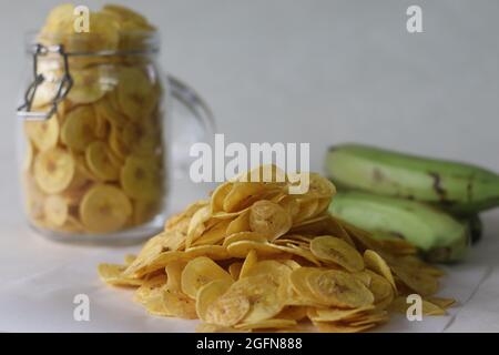 Croustilles de banane frites faites en friture sous des tranches de banane mûres. Un article principal de repas végétariens Onam appelé ethakka uli. Prise de vue sur b blanc Banque D'Images