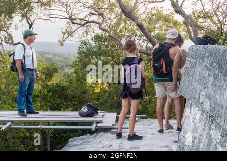 TIKAL, GUATEMALA - 13 MARS 2016 : guide armé et groupe de touristes au Temple IV sur le site archéologique de Tikal, Guatemala Banque D'Images