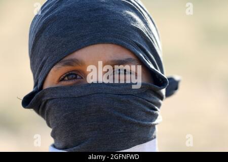 Bande de Gaza. 26 août 2021. Portrait d'une fille palestinienne. Les manifestants palestiniens sont tirés de gaz lacrymogènes tirés par les forces de sécurité israéliennes lors d'une manifestation le long de la barrière frontalière, à l'est de Khan Yunis, dans le sud de la bande de Gaza, dénonçant le blocus israélien du secteur palestinien. Banque D'Images