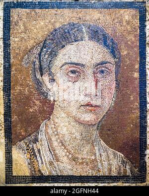 Portrait féminin Mosaïque emblème en opus vermiculatum fabriqué à partir de tesserae polychrome. Le panneau montre une femme avec des caractéristiques bien définies. Ses cheveux sont séparés au centre et elle porte des bijoux, des détails qui datent de la mosaïque de l'ère Julian-Claudian Pompéi Banque D'Images