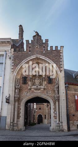 Brugge, Flandre, Belgique - 4 août 2021 : gros plan de la porte d'entrée monumentale et sculptée du palais et musée Gruuthuse sous un ciel bleu clair. Banque D'Images