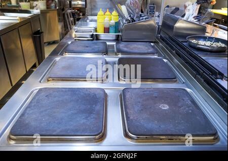 Partie de la cuisinière électrique d'une grande cuisine professionnelle d'un restaurant moderne, avec ustensiles. Équipement de cuisine professionnel. Surface de chauffage Banque D'Images